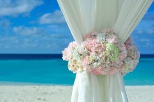 white curtain with flower petals on the beach